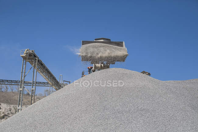 Heavy machinery at quarry, pouring aggregate onto pile — Stock Photo