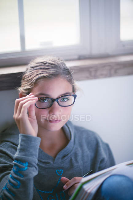 Портрет дівчини, яка робить домашнє завдання на підлозі — стокове фото