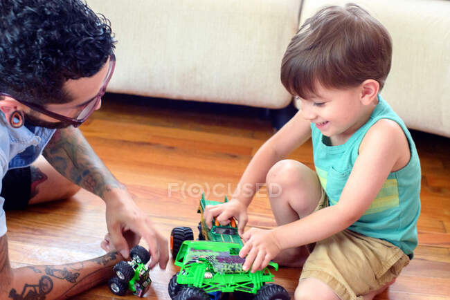 Мужчина смотрит, как сын играет с игрушками — стоковое фото