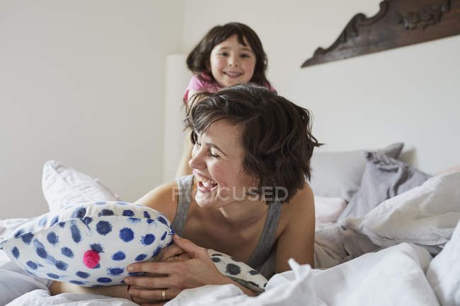 Мати і дочка грають у спальні в світлій спальні — стокове фото