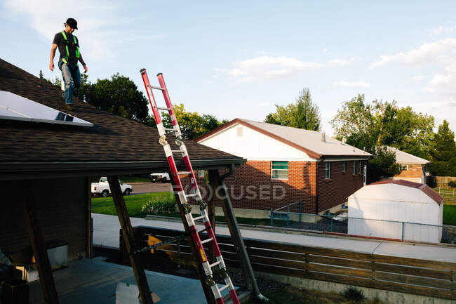 Operaio in piedi sul tetto della casa, l'installazione di pannelli solari — Foto stock