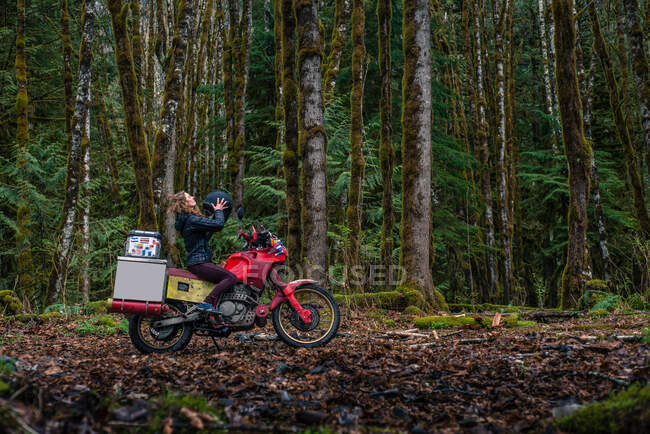 Woman riding motorcycle in forest, Squamish, Canada — Stock Photo