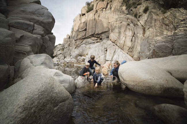 Kinder spielen auf Felsen im Fluss Lake Arrowhead, Kalifornien, USA — Stockfoto