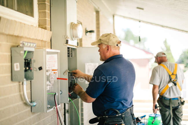 Electrician connecting power cable in porch — Stock Photo