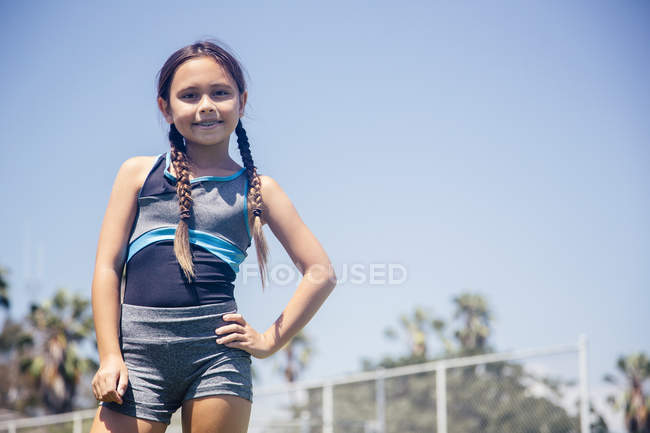 Portrait of schoolgirl with hand on hip on school sports field — Stock Photo