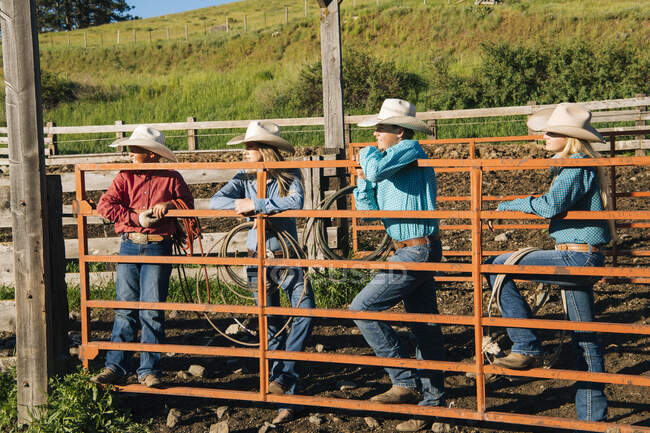 Cowboys e vaqueiras se apoiando no portão, olhando para longe, Enterprise, Oregon, Estados Unidos, América do Norte — Fotografia de Stock