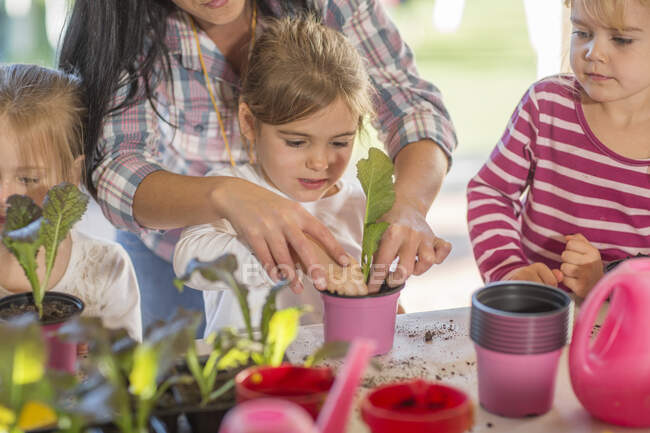 Metà donna adulta aiutare i bambini piccoli con attività di giardinaggio — Foto stock