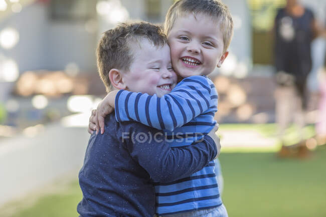 Two young boys, outdoors, hugging — Stock Photo