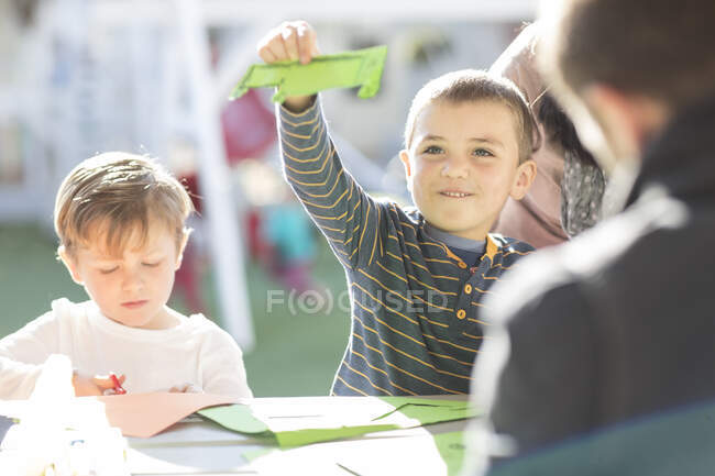Young boys, outdoors, doing crafting activity — Stock Photo