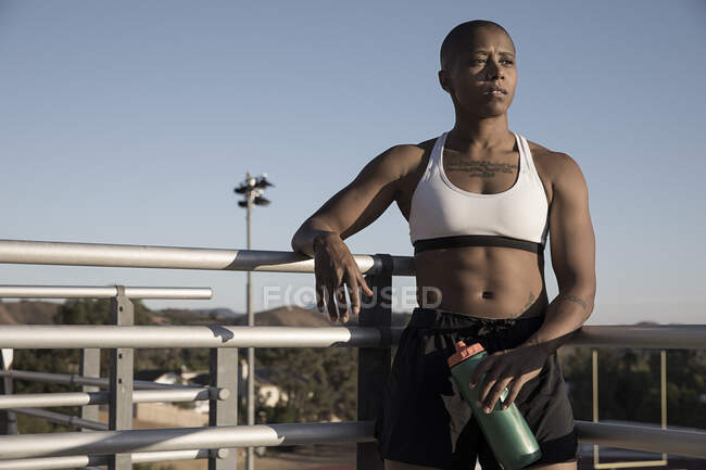 Portrait of woman wearing sports clothing holding water bottle — Stock Photo