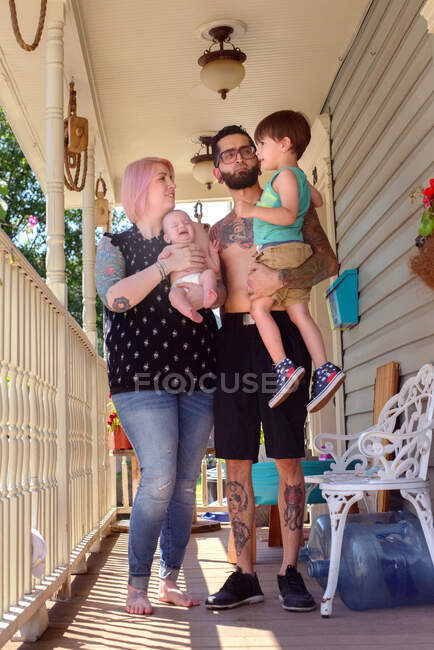 Família na varanda da frente da casa — Fotografia de Stock