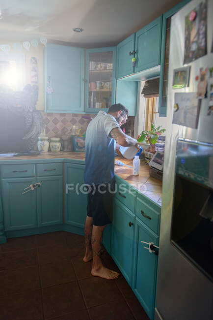 Homem preparando garrafa de leite no balcão da cozinha — Fotografia de Stock
