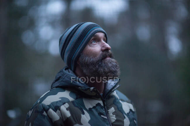 Hombre con sombrero de lana en el bosque - foto de stock