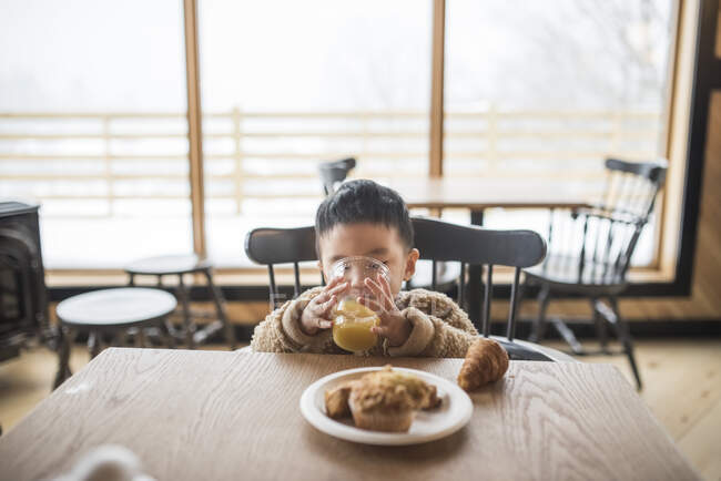 Kleiner Junge trinkt Saft in Restaurant — Stockfoto
