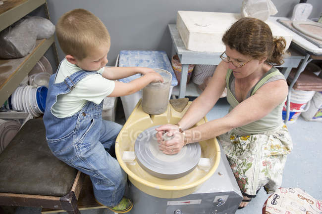 Мать и сын работают с глиной в студии — стоковое фото