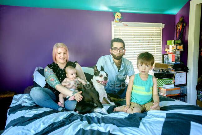 Семья на кровати в спальне — стоковое фото