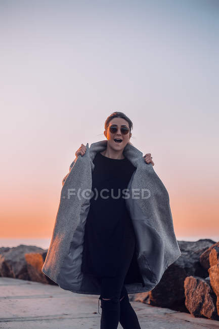 Portrait of woman wearing sunglasses and winter coat posing — Stock Photo