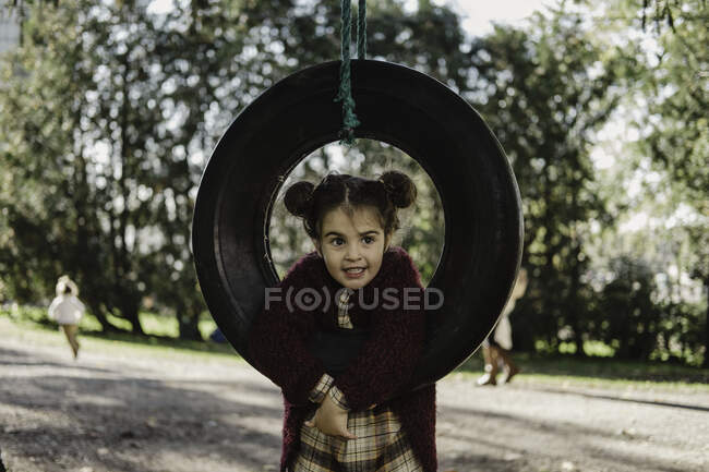 Giovane ragazza che gioca su pneumatico swing — Foto stock