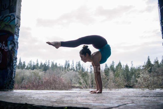 Chica practicando yoga en escenario al aire libre - foto de stock