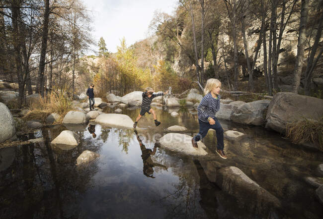 Bambini che giocano sulle rocce del fiume, Lake Arrowhead, California, USA — Foto stock