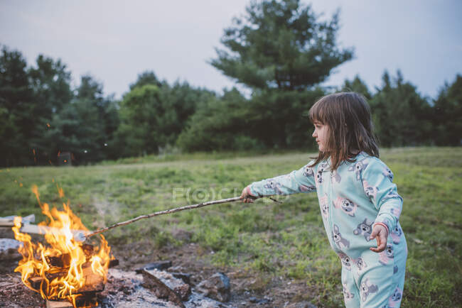 Молодая девушка тост зефир в огне — стоковое фото