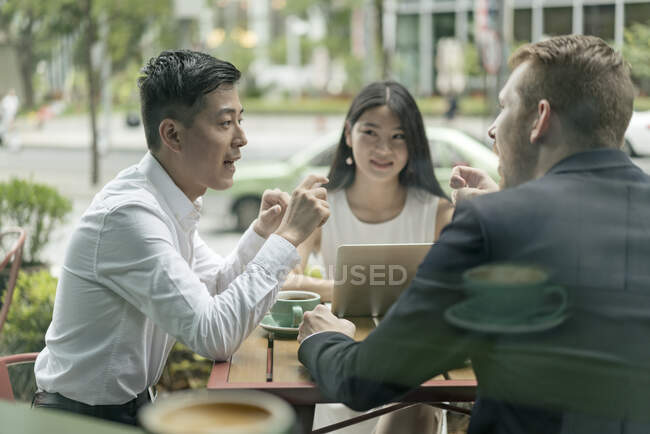 Grupo de empresários, tendo reunião no café, usando laptop, ao ar livre — Fotografia de Stock