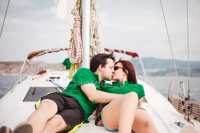 Couple lying on sailboat kissing — Stock Photo