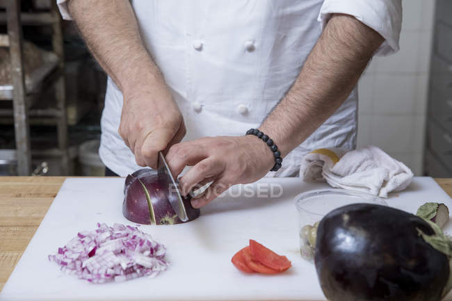 Vue coupée du chef tranchant l'oignon rouge — Photo de stock