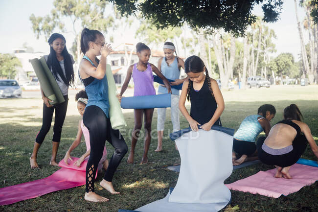 Écolières se préparant pour la pratique du yoga sur le terrain de sport scolaire — Photo de stock