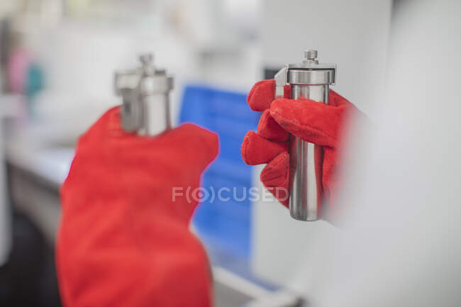 Worker in thread factory, holding beakers of dye, close-up — Stock Photo