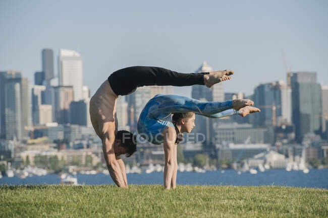 Підліткова дівчинка і молодий чоловік на вулиці, врівноважені руки в позиції йоги — стокове фото