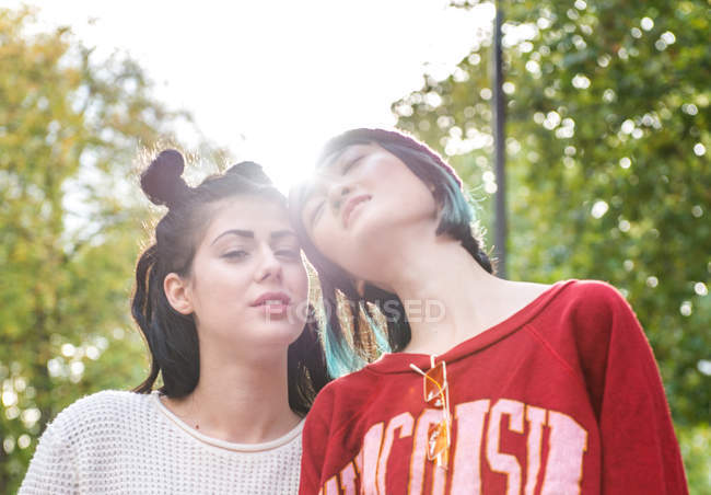 Retrato de duas jovens mulheres elegantes no parque da cidade — Fotografia de Stock