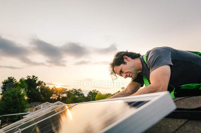 Працівник встановлює сонячні панелі на даху — стокове фото