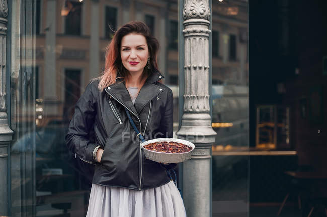 Ritratto di donna in strada che tiene piatto di cibo — Foto stock