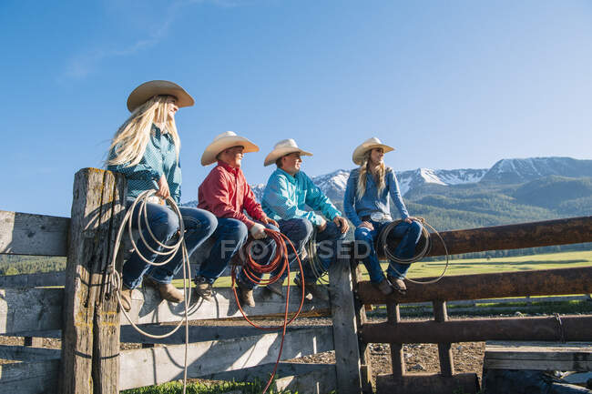 Cowboys and cowgirls on fence, looking away, Enterprise, Oregon, Estados Unidos, Norteamérica - foto de stock