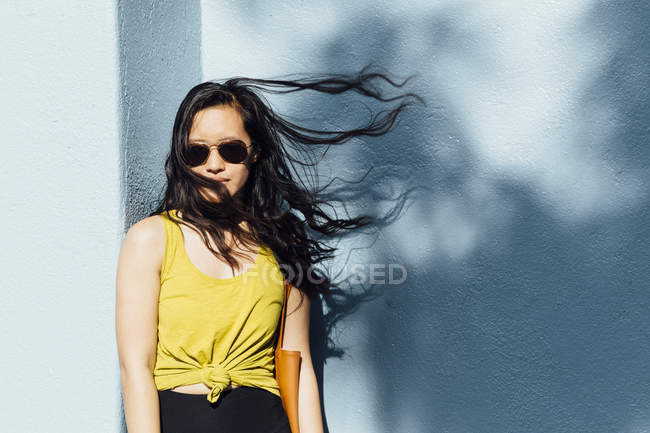 Портрет молодой женщины на улице, волосы, развевающиеся на ветру — стоковое фото