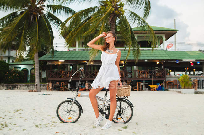 Jovem mulher com bicicleta olhando para longe na praia de areia, Krabi, Tailândia — Fotografia de Stock