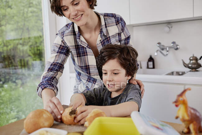 Mère et fils préparant la nourriture dans la cuisine — Photo de stock