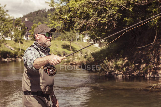 Pêcheur mature pêchant dans la rivière, Mozirje, Brezovica, Slovénie — Photo de stock