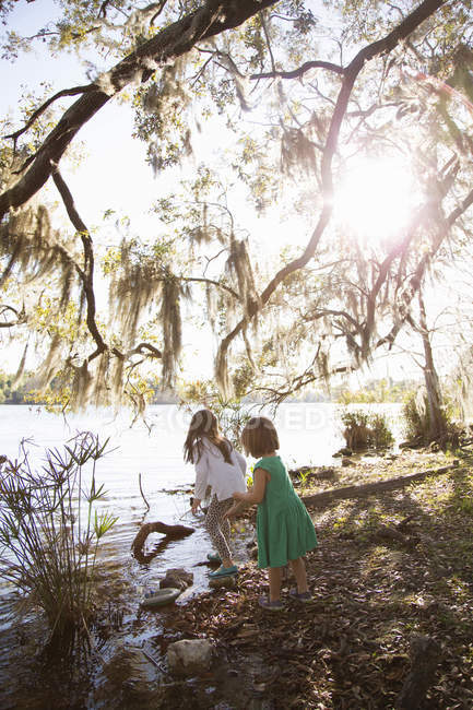 Two girls playing by lake, Orlando, Florida, United States, North America — Stock Photo