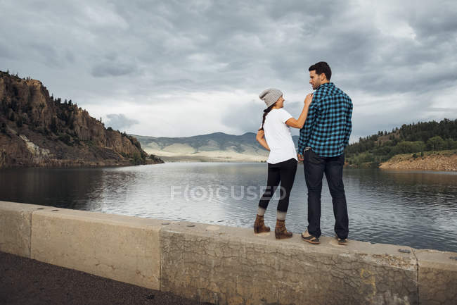 Couple standing on wall beside Dillon Reservoir, Silverthorne, Colorado, USA — Stock Photo