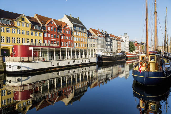 Barcos amarrados y casas de pueblo coloridas del siglo en el canal Nyhavn, Copenhague, Dinamarca - foto de stock