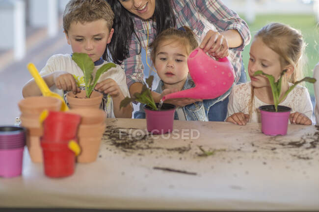 Cape Town, South Africa, teacher helping kids planting seedlings — Stock Photo
