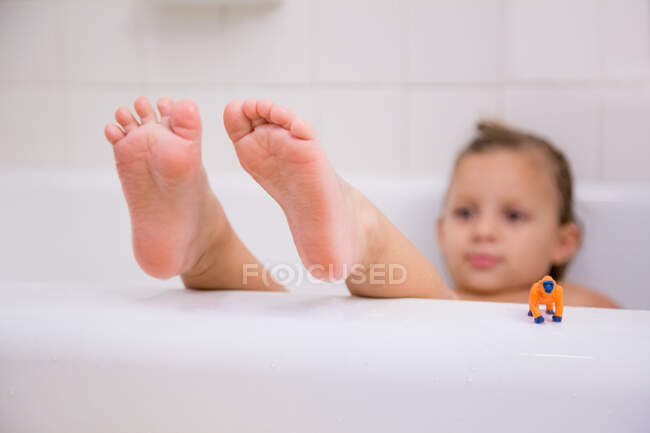 Menina com os pés para cima relaxante no banho — Fotografia de Stock