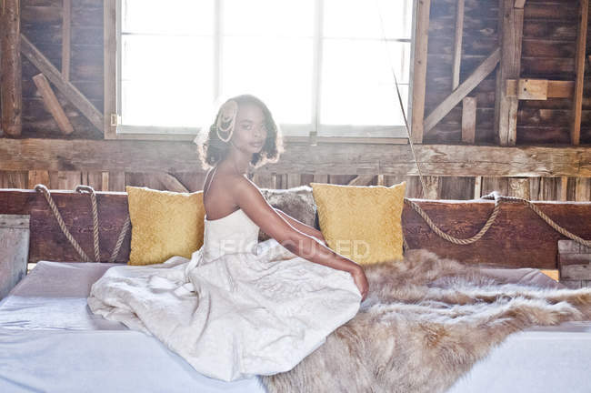 Portrait de mariée en robe de mariée assis dans la grange — Photo de stock