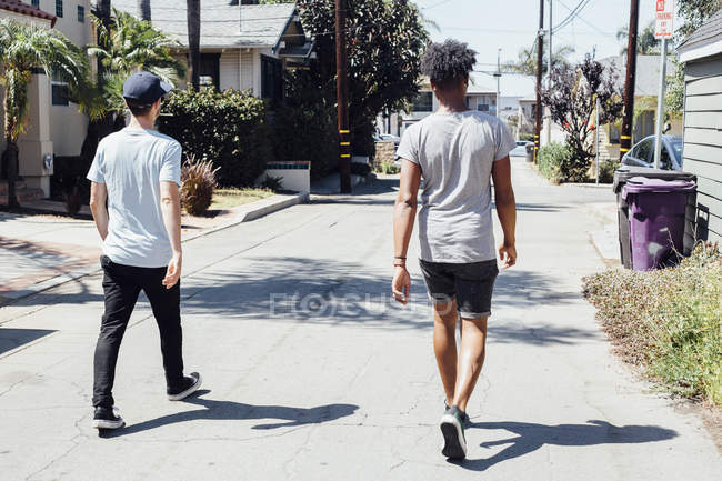Amici che camminano lungo la strada soleggiata, Long Beach, California, Stati Uniti — Foto stock
