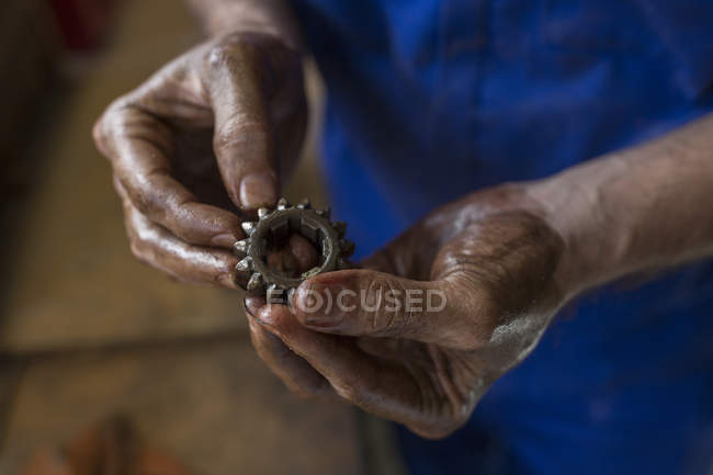 Close up of mechanic holding car part — Stock Photo