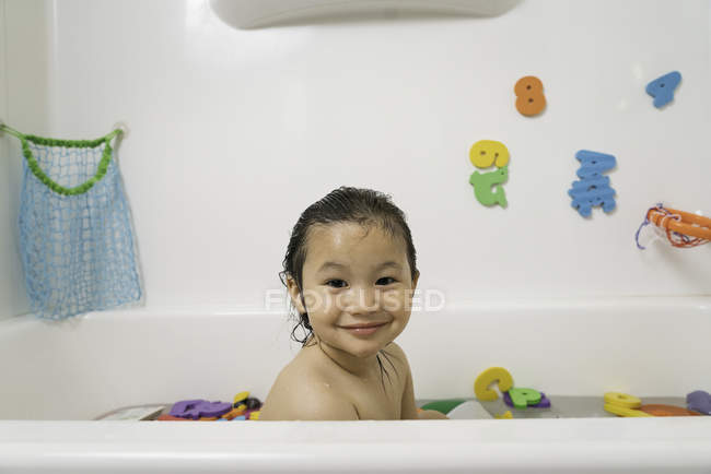 Petit garçon dans la baignoire regardant la caméra — Photo de stock