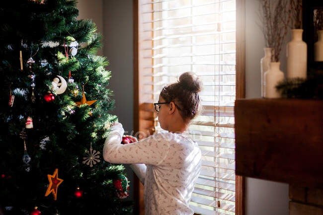 Side view of girl decorating Christmas tree — Stock Photo