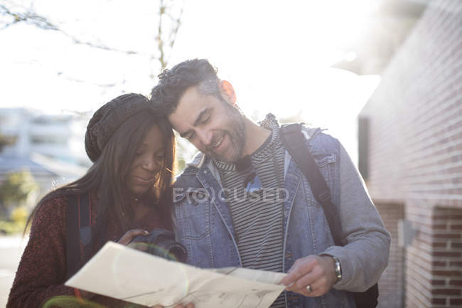 Пара смотрит на карту и женщина держит камеру — стоковое фото